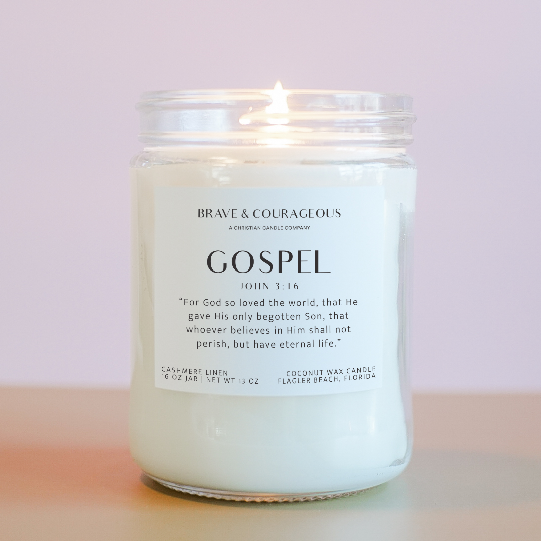 Gospel Candle in a glass jar with a Bible Verse John 3:16 label on a light pink background